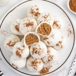 overhead shot of Pumpkin Spice Cheesecake Bites on a plate with one split in half
