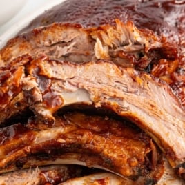 Pinterest graphic of saucy crock pot BBQ baby back ribs with text overlay reading “Melt-in-your-mouth Crock Pot BBQ Baby Back Ribs – Easy Way to Make Ultra-Tender Ribs in the Slow Cooker!”